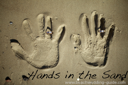 beach wedding hands in the sand